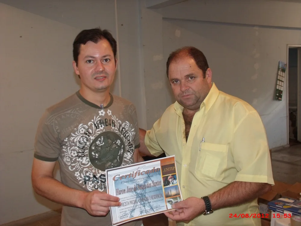 Claudio Moraes ao lado de um aluno com certificado, em registro de sua trajetória no ensino de elétrica